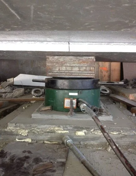 Hydraulic jack positioned beneath the bridge